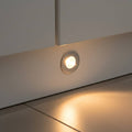 chrome led plinth light shown mounted in a white low level kitchen plinth