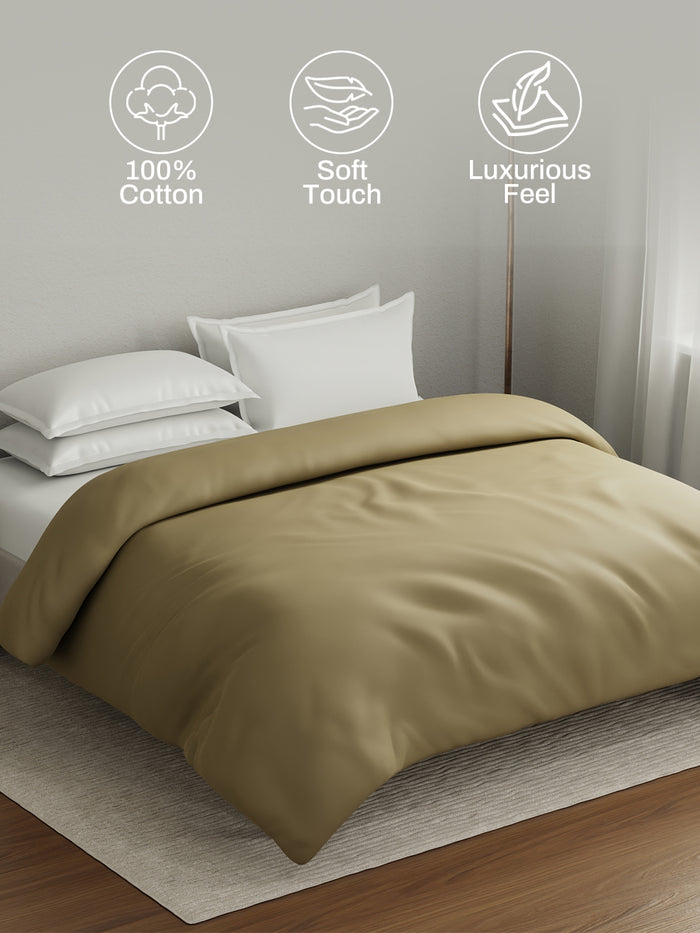 Beige comforter on a bed with 100% cotton, soft touch, and luxurious feel icons above.