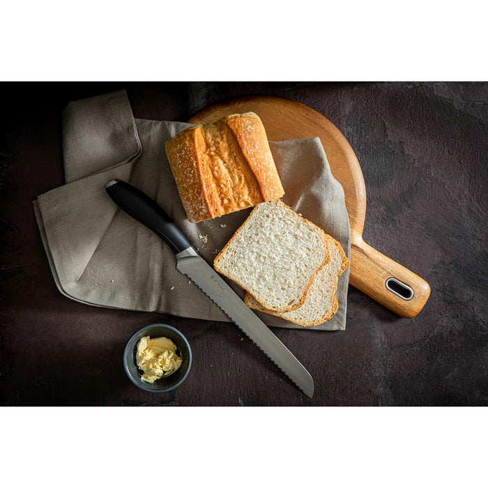 Image shows Circulon bread knife on a tea towel next to a sliced loaf of white bread.