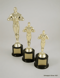 Three gold-tone Achievement figurine trophies on black bases with blank gold nameplates, arranged by size on a light gray background.