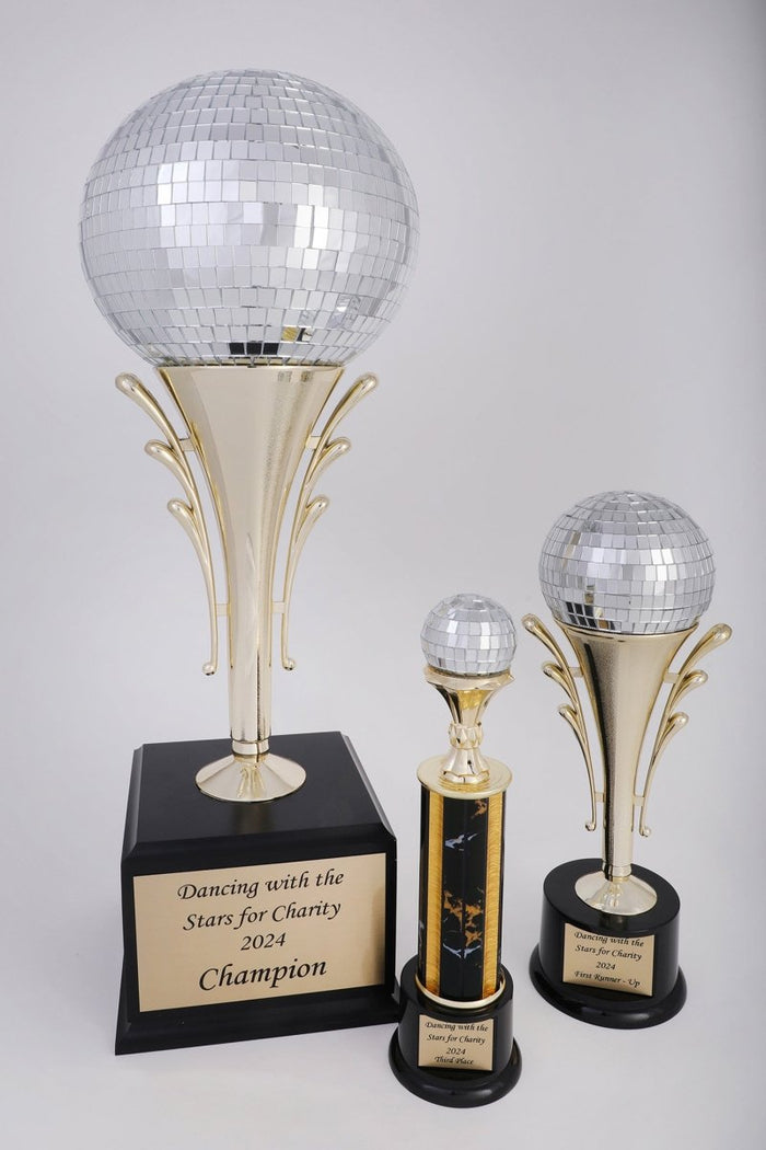 A trophy featuring a black round base with a gold-colored riser, holding a 4 inch mirror disco ball, and includes a plaque with engraving.
