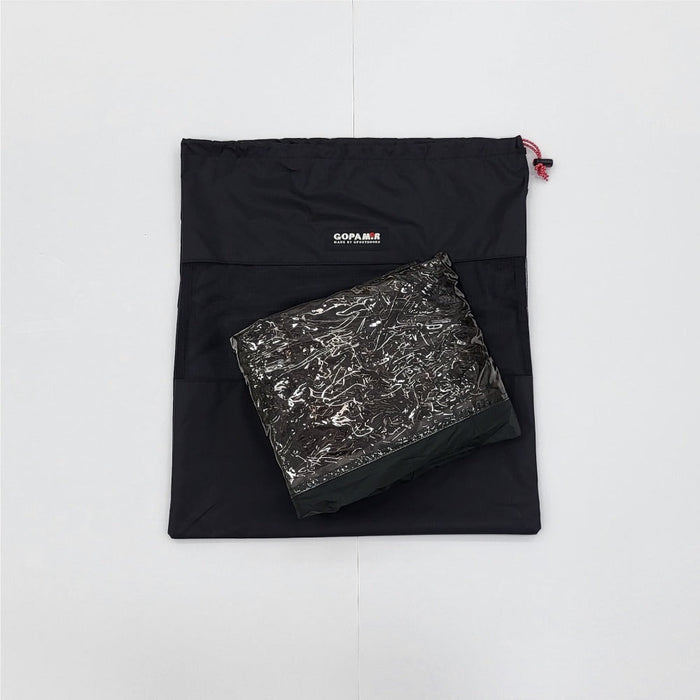 Folded Gopamir G450 body TPU door in clear wrap atop its black drawstring storage bag, studio white background