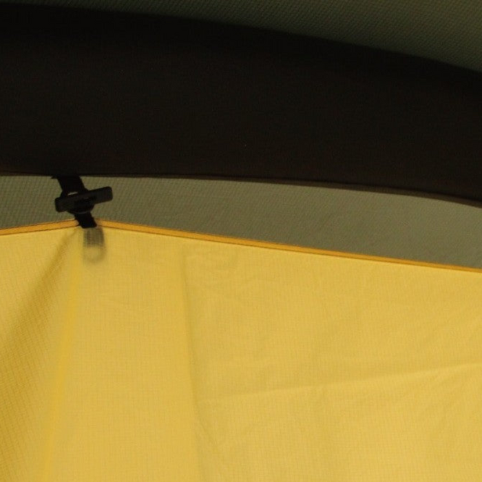 Close-up of a black toggle clip fastening the yellow T720+ Inner Liner edge to the shelter's air-beam frame