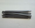 Folded Gopamir TN600 spare pole sections in gunmetal aluminum laid on a plain studio background