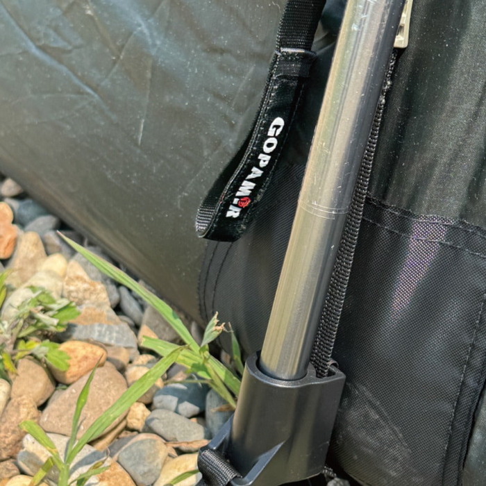 TN600 spare pole tip seated in its black end cap with Gopamir logo strap, shown beside pebbles and grass