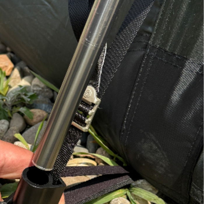 Hand fitting the TN600 spare pole into its base socket, with metal buckle strap tensioner on dark tent fabric