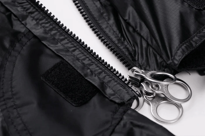 Close-up of the Gopamir TN600 TPU panel zipper with twin metal ring pulls and hook-and-loop tab on black fabric