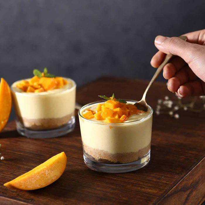 Set of glass dessert bowls displayed on a table with ice cream.
