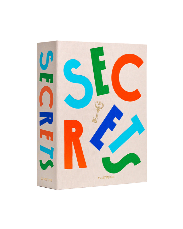 A hardcover book titled 'SECRETS' with large, colorful letters in blue, green, orange, and red on a cream-colored cover, featuring a small gold key graphic and the brand name 'PROTESTED' at the bottom.