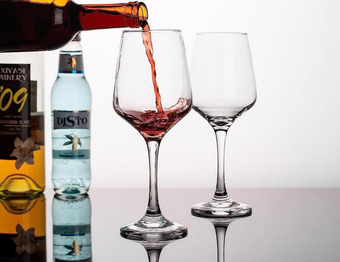 Simple wine glass displayed with a bottle of wine.