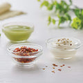Clear glass bowls filled with mint and dry spices.