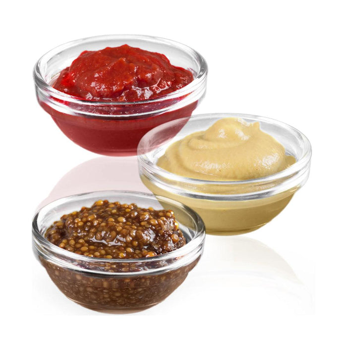 Stackable glass bowls on a table with dips and sauces.