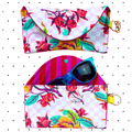 A multicolored floral sunglasses case with a snap closure and a keychain attachment.